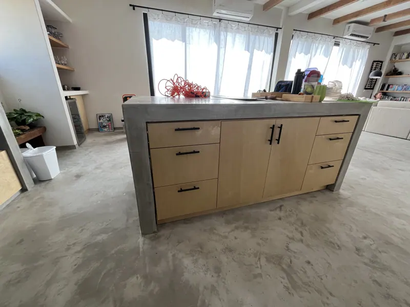 Kitchen island with wood drawers and concrete waterfall counter