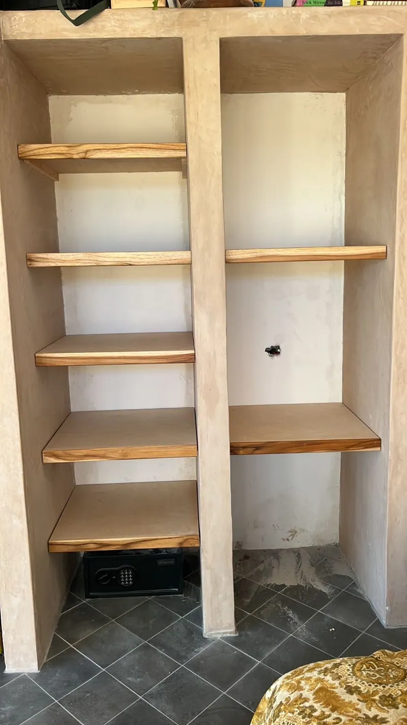 Wood shelves set into a plaster niche