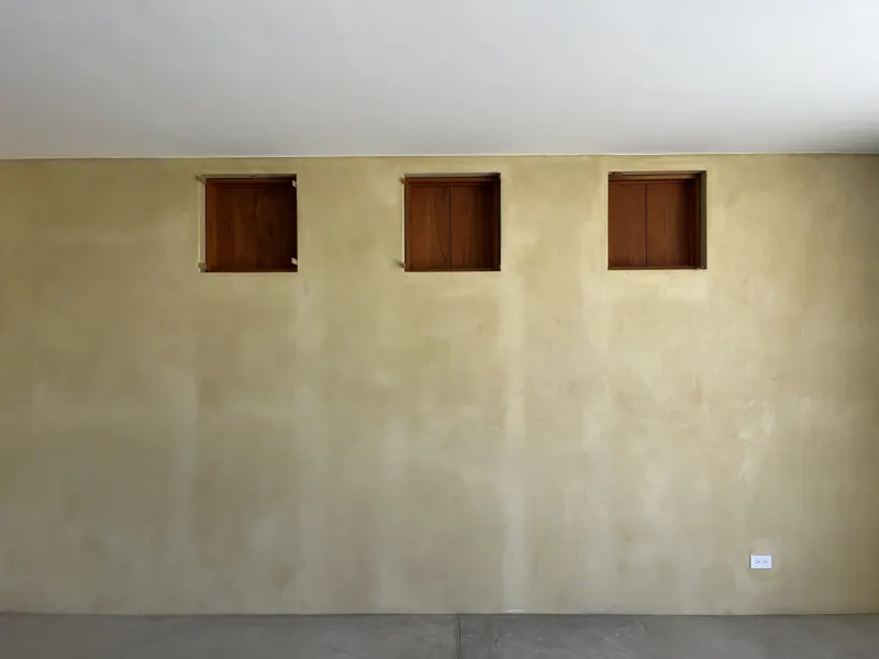 Three small wood shutters in a plaster wall