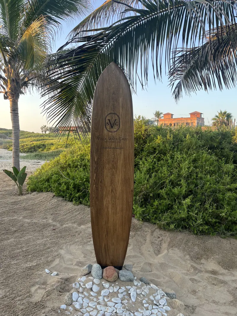 Wooden surfboard standing on the beach